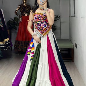May include: A colorful, tiered skirt with a heart-shaped bodice. The bodice is adorned with intricate embroidery in various colors. The skirt features panels of white, pink, green, purple, and navy blue. The text "SR-00001" is in the upper right corner.