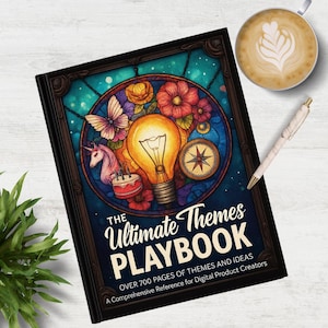 May include: A hardback book titled "The Ultimate Themes Playbook" with a colourful illustration of a lightbulb, flowers, and a compass. The book is on a white wooden surface, next to a cup of coffee and a pen.