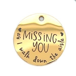 May include: Gold-colored round charm with the text "as I walk down the aisle, missing you" and two hearts.