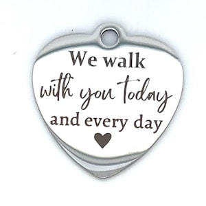 May include: Silver heart-shaped charm with the inscription "We walk with you today and every day" and a small heart at the bottom.