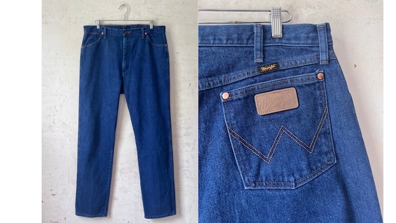 May include: A pair of blue denim jeans with a brown leather Wrangler patch on the back pocket.