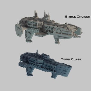 May include: Two detailed model spaceships, a Strike Cruiser and a Town Class, are displayed against a light gray background. The Strike Cruiser is light gray, and the Town Class is dark gray. Text labels identify each ship.