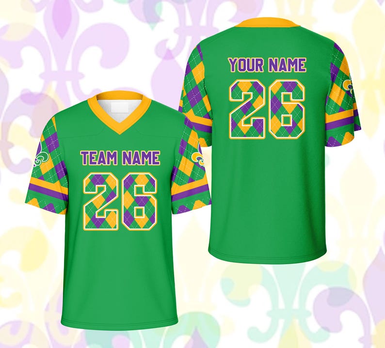 Op de afbeelding: Twee groene voetbalshirts met gouden en paarse accenten. Het shirt aan de voorkant heeft "TEAM NAME" en het nummer "26". Het shirt aan de achterkant heeft "YOUR NAME" en het nummer "26". De shirts hebben een V-hals en korte mouwen.