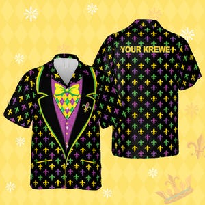 Peut inclure: Une chemise noire à manches courtes avec un motif de style smoking. La chemise présente un gilet violet avec un nœud papillon jaune et vert, et une veste noire avec une bordure verte. Elle est couverte de symboles de fleur de lys verts, violets et jaunes. Le texte "YOUR KREWE" est au dos.