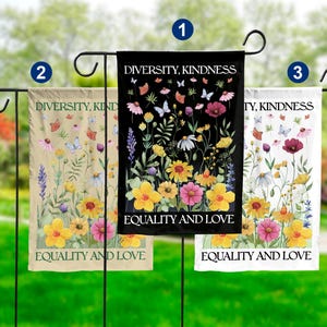 May include: Three garden flags with a floral design and the text "Diversity, Kindness, Equality and Love". The flags are on black, white, and beige backgrounds.