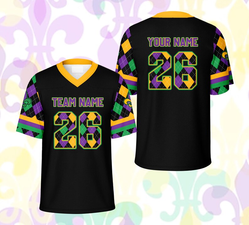 Op de afbeelding: Zwart voetbalshirt met gouden, paarse en groene accenten. De voorkant toont "TEAM NAME" en het nummer "26" in een ruitpatroon. De achterkant heeft "YOUR NAME" en het nummer "26".