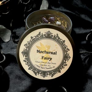 May include: A black candle jar with a gold label that reads "Nocturnal Fairy" Hand Poured Soy Candle Net Wt 4 oz.  Ash Coal Candles LLC.