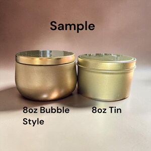 May include: Two gold-colored metal containers with lids. The left container is a rounded 8oz bubble style vessel, and the right is a cylindrical 8oz tin. The text "Sample", "8oz Bubble Style", and "8oz Tin" is visible in the image.