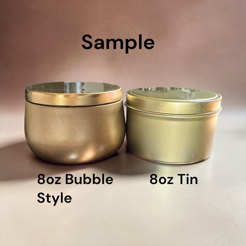 May include: Two gold-colored metal containers with lids. The left container is a rounded 8oz bubble style vessel, and the right is a cylindrical 8oz tin. The text "Sample", "8oz Bubble Style", and "8oz Tin" is visible in the image.