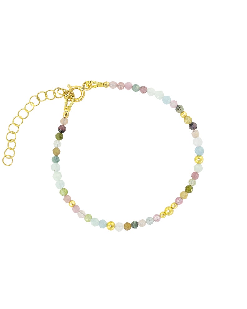 May include: A gold beaded bracelet with a variety of colorful gemstones, including pink, green, and blue. The bracelet has a lobster clasp closure.