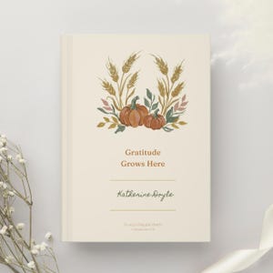 May include: A cream-colored hardcover book featuring a watercolor illustration of two orange pumpkins surrounded by wheat stalks and green leaves. The text reads Gratitude Grows Here, Katherine Doyle, and In every thing give thanks 1 Thessalonians 5:18.