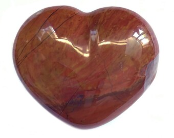 Puede incluir: Una piedra de jaspe rojo pulida en forma de corazón con vetas marrones y blancas.