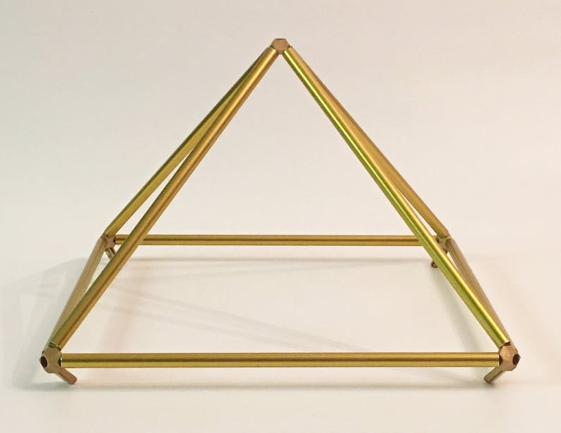 K&ouml;nnte beinhalten: Eine goldfarbene Metallpyramide mit quadratischer Basis. Die Pyramide besteht aus vier St&auml;ben, die an den Ecken miteinander verbunden sind. Die St&auml;be sind glatt und haben eine gl&auml;nzende Oberfl&auml;che.