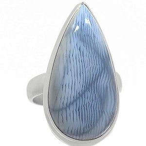 May include: A silver ring with a teardrop-shaped blue agate stone. The stone has a white and blue pattern.