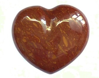 Puede incluir: Una piedra pulida en forma de corazón con un patrón de mármol rojo y marrón.