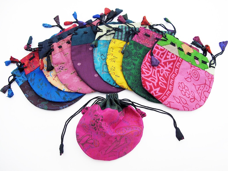 May include: A collection of 12 colorful drawstring pouches made from recycled silk fabric. Each pouch features a unique pattern and is perfect for storing small items like jewelry, coins, or trinkets.