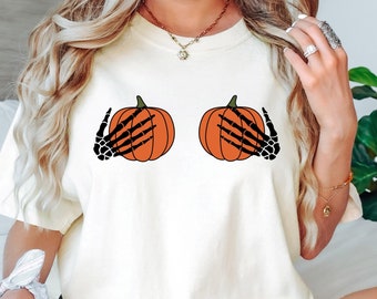 Grappige Halloween-pompoentieten vastgehouden door skelethandshirt, pompoenshirt, pompoenkruidshirt, pompoenseizoenshirt, skelethandshirt