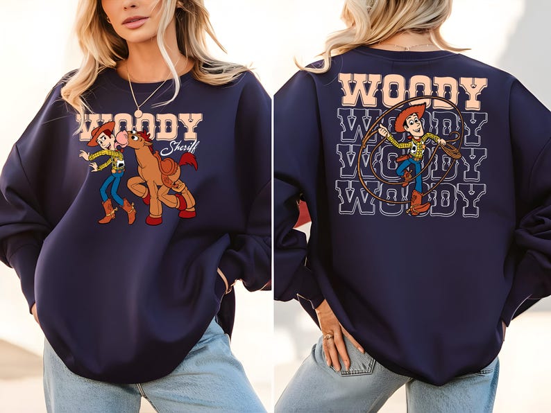 Puede incluir: Sudadera azul marino con un gr&aacute;fico de dibujos animados de Woody y un caballo en la parte delantera. La parte posterior de la sudadera tiene un gr&aacute;fico de Woody con un lazo y la palabra "WOODY" repetida. La sudadera tiene mangas largas.