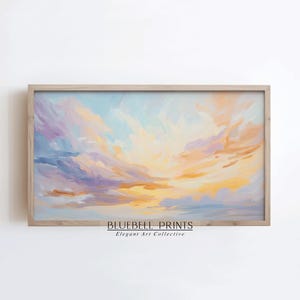 Pode incluir: Uma pintura de um pôr do sol colorido com um céu azul claro, roxo e amarelo. A pintura é emoldurada em uma moldura de madeira clara. O texto "BLUEBELL PRINTS Elegant Art Collective" está na parte inferior da pintura.