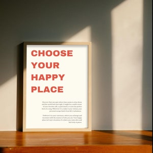 Könnte beinhalten: Ein gerahmter Druck mit weißem Hintergrund und rotem Text, der "Wähle deinen glücklichen Ort" lautet. Dem Text folgt ein kurzer Absatz darüber, einen Ort zu finden, an dem man sich in Frieden fühlen kann.