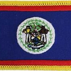 Può includere: Toppa rettangolare raffigurante la bandiera del Belize. La bandiera ha uno sfondo blu con strisce rosse in alto e in basso. Il centro presenta un cerchio bianco con lo stemma del Belize e una frangia gialla borda la toppa.