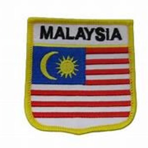 May include: A rectangular patch featuring the Malaysian flag. The flag design includes a blue canton with a yellow crescent and star, and red and white stripes. The word "MALAYSIA" is above the flag in black letters, with a yellow border.