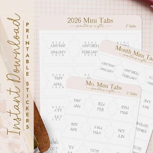 Könnte beinhalten: Druckbare Aufkleberbögen mit 2026 Mini-Tabs für die monatliche und jährliche Organisation. Die Tabs sind in einem weichen Beige mit goldfarbenen Buchstaben gehalten. Der Text enthält Monate und das Jahr 2026.