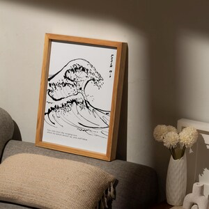 May include: A black and white print of a large wave with the text "You only see the surging sea, when its waves mount up, you still seem" in a wooden frame.