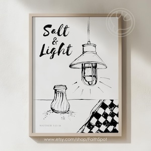 Puede incluir: Lámina artística enmarcada en blanco y negro con las palabras "Salt & Light" en escritura manuscrita. La imagen presenta un salero, una lámpara colgante y un patrón de cuadros. También se incluye el texto "Matthew 5:13-16".