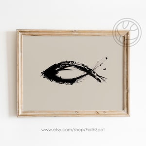 Puede incluir: Una pintura abstracta en blanco y negro de un símbolo de pez, también conocido como Ichthys, en un marco de madera marrón claro.
