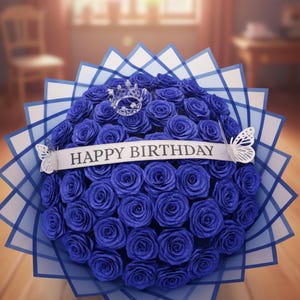 May include: A large bouquet of deep blue glittery roses wrapped in white and blue checkered paper. A white ribbon across the centre reads HAPPY BIRTHDAY. A small silver crown sits near the top, and two white butterfly cutouts adorn the sides.