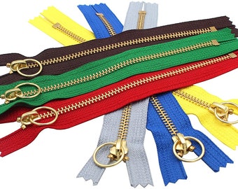 May include: Assortment of six zipper closures with gold metal teeth and sliders. The zippers are in various colors: red, green, brown, yellow, blue, and gray.