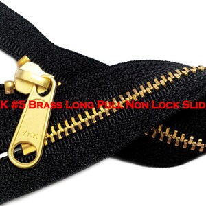 Pode incluir: Um z&iacute;per preto YKK #5 com um cursor longo sem trava de lat&atilde;o. O z&iacute;per est&aacute; fechado e o cursor est&aacute; no meio do z&iacute;per.