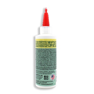 Peut inclure: Une bouteille en plastique transparente avec un bouchon rouge remplie d'un adh&eacute;sif blanc. L'&eacute;tiquette de la bouteille est verte et jaune et comprend le texte "GEM-TAC" et "Colle les embellissements sur de nombreuses surfaces, y compris le verre, le plastique et plus encore."