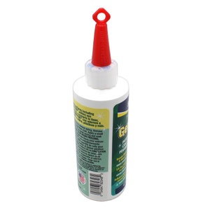 Peut inclure: Une bouteille blanche avec un bouchon rouge et une &eacute;tiquette verte. L'&eacute;tiquette indique "Gel-Crafter" et "Colle de contact permanente".