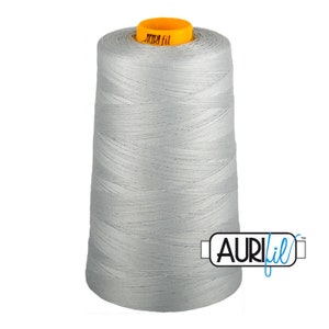 Puede incluir: Una bobina de hilo gris plateado con el texto "AURIfil" en la etiqueta.