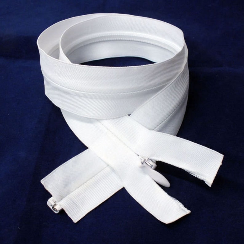 May include: White zipper tape with a white slider. The zipper is folded in half and the ends are visible.