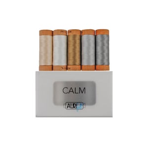 May include: A set of five spools of Aurifil thread in the "Calm" color collection. The spools are wrapped in wooden bobbins and feature a variety of neutral colors, including beige, white, gold, silver, and gray.