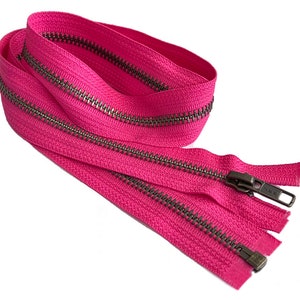 May include: A pink zipper with antique silver teeth. The zipper is folded in half and the ends are visible.