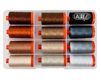 May include: A clear plastic storage box with 12 spools of thread. The spools are arranged in three rows of four. The spools are in shades of brown, beige, and gray. The box has a label that says "Aurifil".