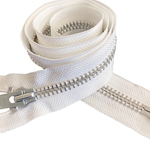 Puede incluir: Cremallera blanca enrollada con tirador y dientes de metal plateado. La cinta de la cremallera presenta un patrón de espiga. Ideal para ropa, bolsos u otros proyectos de costura. La cremallera está hecha de tela tejida.
