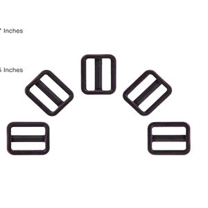 Puede incluir: Seis hebillas deslizantes de pl&aacute;stico negro, cada una mide 2,63 cm por 3,19 cm. Las hebillas est&aacute;n dispuestas en forma de semic&iacute;rculo.