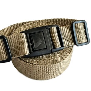 May include: A tan nylon strap with a black plastic buckle. The strap is rolled up and the buckle is visible.