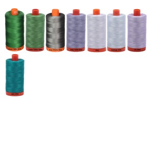 May include: A collection of ten spools of thread in various colors, including green, grey, blue, and purple. The spools are labeled with their color and number.