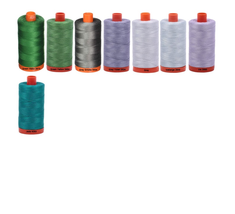 May include: A collection of ten spools of thread in various colors, including green, grey, blue, and purple. The spools are labeled with their color and number.