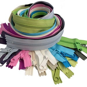 May include: A collection of colorful zippers in various shades, including gray, pink, green, and blue. The zippers are arranged in a spiral, with several individual zippers fanned out below. The image is on a white background.