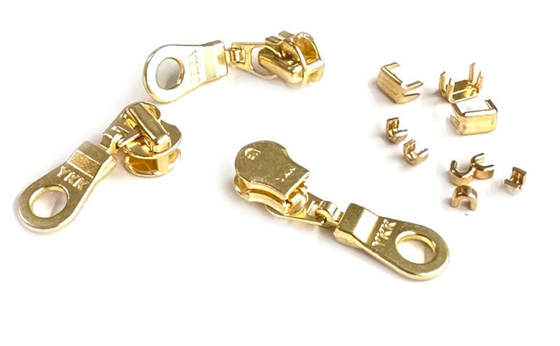 Puede incluir: Tiradores de cremallera de color dorado con la marca YKK y un juego de topes de cremallera de color dorado.