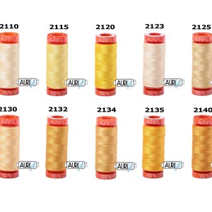 May include: Ten spools of Aurifil thread in various shades of yellow and cream. The spools are labelled with the Aurifil logo and the thread number.