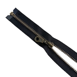 May include: A black zipper with a brass slider and pull. The zipper is open and the teeth are visible.