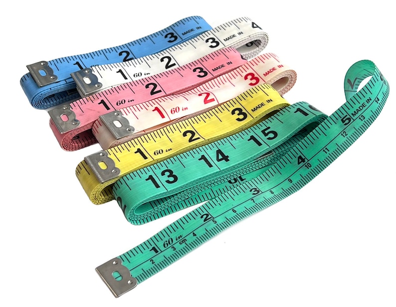 May include: A set of five colorful measuring tapes, each with a different color: blue, white, pink, yellow, and green. The tapes are all marked in inches and have the words "Made in" printed on them.